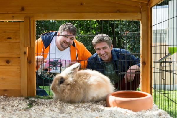 Bild 1 von 6: Ferien in Bärstadt: Fritz Fuchs (Guido Hammesfahr, r.) will mit Keks eine Radtour machen und hofft deshalb, dass er sich nicht um die Kaninchen und den Garten von David (Daniel Zillmann, l.) kümmern muss.