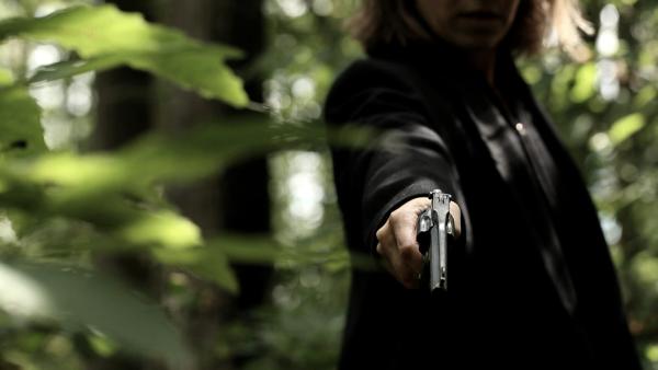 Bild 1 von 3: Mit der Waffe ihres Ehemanns schießt Bettina Beau auf ihren Chef. Nach dem Mord legt sie die Waffe zurück an ihren Platz.