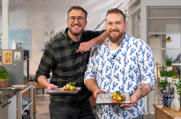 Bild 1 von 2: Sören Anders (li.) und Frédéric Morel haben, aus den übrig gebliebenen Zutaten, eine Tortilla - natürlich aus Buchweizenmehl - mit Käse und Zwiebeln kreiert. Belegt mit Rosenkohl, Tomatensauce, Kasseler und Kräutertopping.
