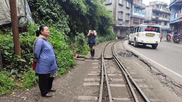 Bild 1 von 5: Die 90 Kilometer lange Strecke nach New Jalpaiguri führt oft mitten durch kleine Städte. Hier wartet eine Mitarbeiterin darauf, die Weiche für den Zug umzustellen.