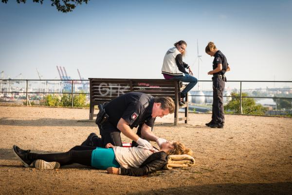 Bild 1 von 9: Während Hans (Bruno F. Apitz) nach Annalena (Zarina Zöller) sieht, die durch einen Messerstich verletzt wurde, lässt sich Franzi (Rhea Harder-Vennewald, r.) von Britta (Vivien Fröhlich, 2.v.r.) die Beschreibung des Täters geben.