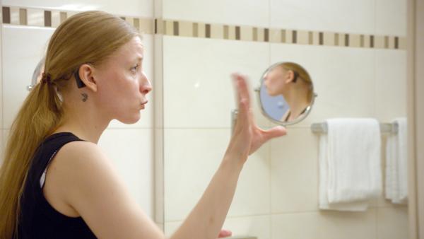 Bild 1 von 8: Cindy Klink steht vor dem Spiegel und probt Deaf Performance - eine visuelle Kunstform, bei der taube Künstler Musik durch Gebärdensprache, Mimik und Tanz performen.