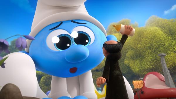 Bild 1 von 1: Gargamel versucht den riesig gewordenen Baby Schlumpf mit einer Flasche Milch zu beruhigen.