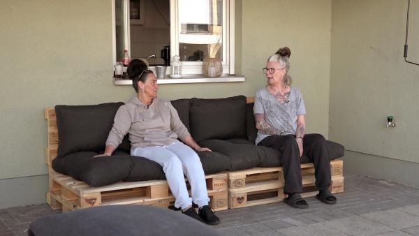 Bild 1 von 4: Beate (re.) und Freundin Ela bauen die Sitzgruppe aus Paletten auf.