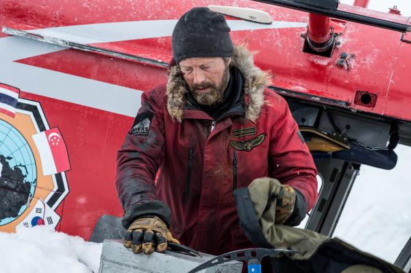 Bild 1 von 12: Overgård (Mads Mikkelsen) muss die Situation neu überdenken und sichert zunächst einmal brauchbare Ausrüstung des abgestürzten Helikopters.