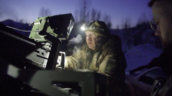 Bild 1 von 8: Oleg, der Kommandant der zivilen Luftverteidigungseinheit in der Nähe von Kiyv, erklärt exactly-Reporter Milan Schnieder die Funktionsweise des Luftabwehr-Maschinengewehrs.