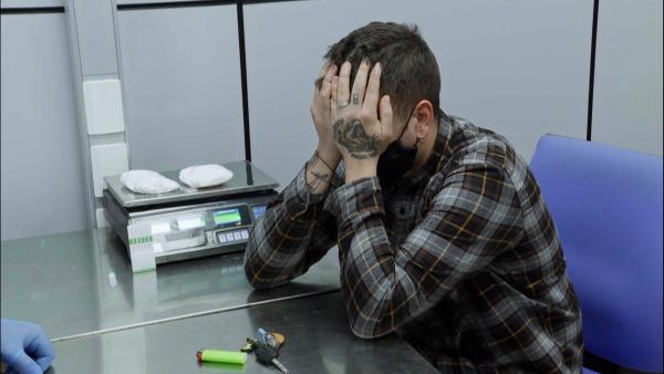 Bild 1 von 2: in Augenblick der Ernüchterung: Die Beamten wiegen die gefundenen Pakete, während der Reisende realisiert, dass seine Schmuggelversuche gescheitert sind.