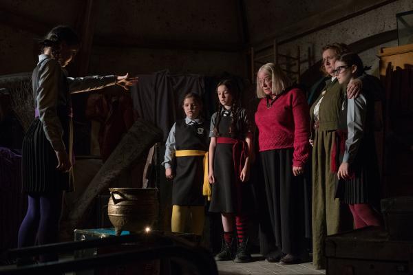Bild 1 von 5: In diesem Moment entscheidet sich die Zukunft der Akademie! Zusammen mit Mildred (Bella Ramsey, 3. von l.) ist Ada Graustein (Clare Higgins, M.) in die Akademie der Vergangenheit gelangt, und dort auf ihre Mutter Alma (Gillian Waugh, 2. v. r.), sich selbst (Clare Glower, r.) und ihre Zwillingsschwester Agatha (Sarah Gower, von hinten) als junge Mädchen gestoßen.