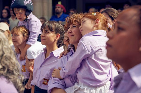Bild 1 von 3: Estel (Betsy Túrnez) und ihre Tochter Clàudia (Giulieta Scattolini) sehen zu, wie die Colla Castellera einen traditionellen menschlichen Turm baut.