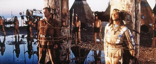 Bild 1 von 8: Winnetou (Pierre Brice, r.) und Old Shatterhand (Lex Barker, l.) geraten in einen Hinterhalt und sollen am Marterpfahl sterben ...