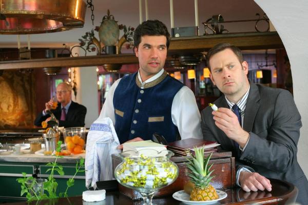 Bild 1 von 1: Im Bild: Kommissar König (Mark-Alexander Solf, r.) glaubt, dass Barkeeper Martin Lindner (Moritz Tittel, l.) den Cocktail vergiftet hat, um Plessen zu beseitigen.