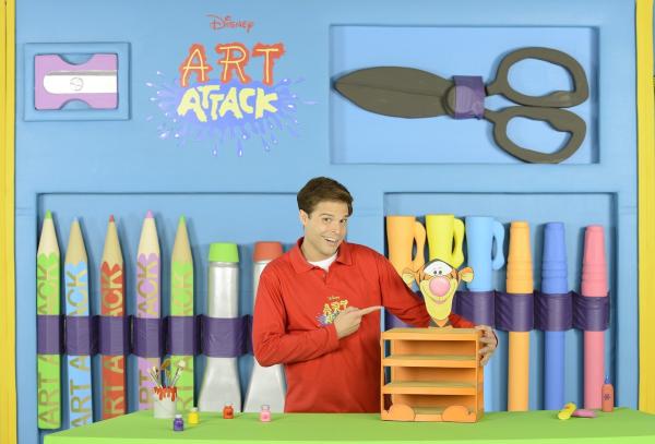 Bild 1 von 2: Stifte, Kleber, fertig, los! Das große Basteln beginnt wieder - mit brandneuen Folgen von Art Attack. Moderator Nicolás Artajo führt die kleinen Zuschauer in seine bunte Bastelwelt und verwandelt Alltagsgegenstände in tolle Kunstwerke. Er zeigt, wie man mit wenigen Hilfsmitteln wunderschöne Projekte umsetzt. Damit seine Zuschauer es ihm gleichtun können, wird jeder Handgriff genau erklärt. Schritt für Schritt zeigt Disney Art Attack, wie man aus unscheinbaren Haushaltsgegenständen wie leeren Küchenpapierrollen, Pappkartons, leeren Joghurtbechern und Zeitungspapier die tollsten Sachen zaubert. Dabei wird nicht nur die Fantasie der kleinen Zuschauer angeregt, auch die kreativen und motorischen Fähigkeiten werden gefördert. Nicolás hat sich auch für die elfte Staffel wieder einiges vorgenommen: Neben Big-Band-Instrumenten, einer Piratentaverne aus Holzstäbchen oder dreidimensionalen Hügelbildern und einem Lenker-Clown für den Roller oder das Fahrrad werden auch fliegende Topfpflanzen nachgebastelt.
