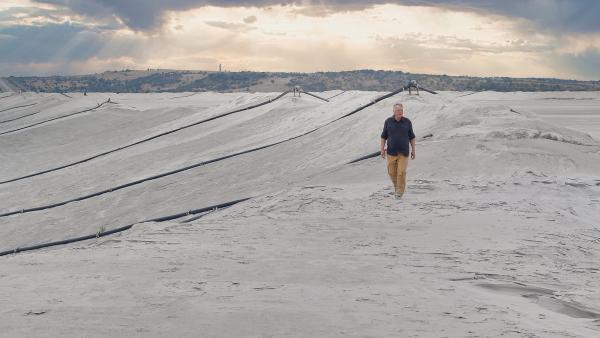 Bild 1 von 4: Colin Devey ist in der Nähe der südafrikanischen Mponene Mine inmitten eines Berges aus Gesteinsmehl, das beim Abbau von Gold anfällt.