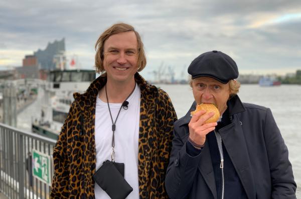 Bild 1 von 1: Pierre (re.) trifft Schauspieler Lars Eidinger zum gediegenen Fischbrötchenessen in Hamburg. Dabei papperlapappen die Beiden über ihre Ökobilanz, Masken und warum man einen Glühwein nach dem Grasrauchen trinkt.