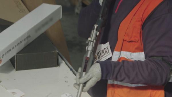 Bild 1 von 2: Eine Schusswaffe wird bei einer Routinekontrolle genau überprüft - der Fund sorgt für erhöhte Sicherheitsmaßnahmen.