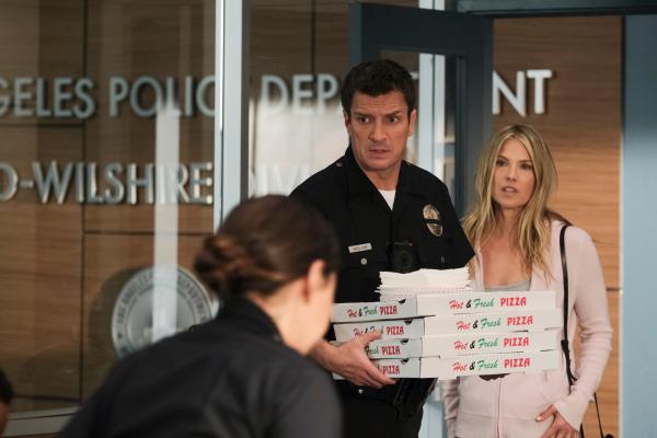 Bild 1 von 2: Grace Sawyer (Ali Larter, r.), John Nolans (Nathan Fillion, l.) Freundin, überrascht die Absolventen mit Pizza.