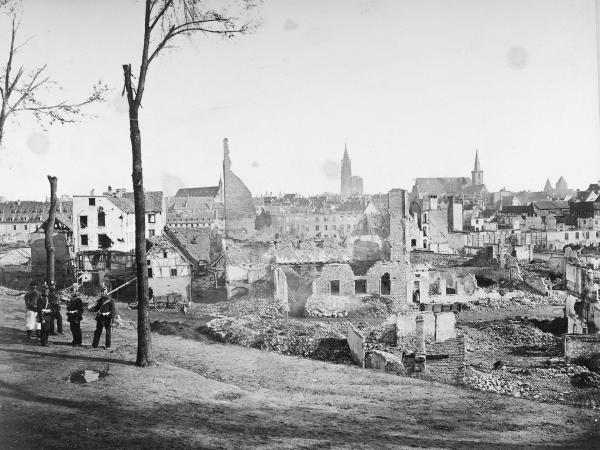 Bild 1 von 6: Badische Infanteristen und preußische Landwehrmänner blicken nach der Kapitulation Straßburg am 28. September 1870 auf die Ruinen der Nationalvorstadt, 1870.