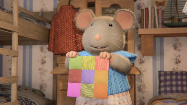 Bild 1 von 2: Sams Mutter zeigt Julia ein selbstgebasteltes Patchwork-Viereck. Alle Familien im Haus basteln solche Vierecke, die dann zu einem großen Patchwork-Bild zusammengelegt werden. Julia möchte nun unbedingt auch ein Viereck basteln.© ZDF/Cielo Films/Caribara Production/SuperswissRed/M.A.R.K.13/ZDF Studios GmbH - Honorarfreie Verwendung gemäß AGB im redaktionellen Zusammenhang mit genannter Sendung bei Nennung \