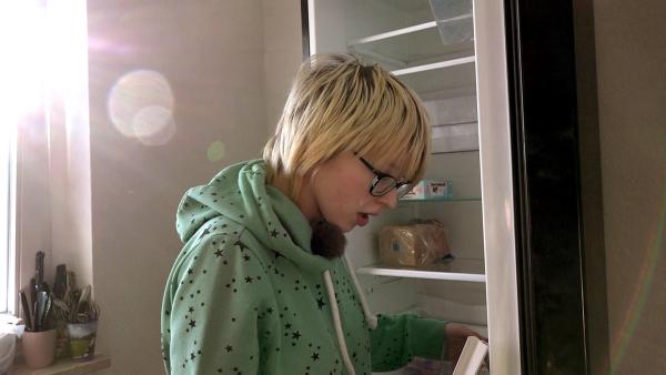 Bild 1 von 3: Die schwangere Jasmin räumt den Kühlschrank ein
