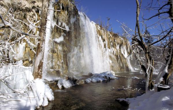Bild 1 von 8: Vereister Kaskadenfall, Wasserbecken im Vordergrund.
