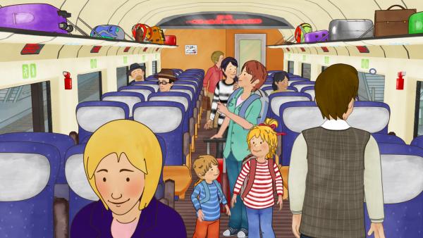 Bild 1 von 5: Conni und Jakob suchen im Zugwagen ihre Sitzplätze.