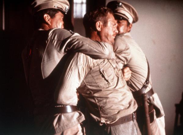 Bild 1 von 4: Der aufsässige Sträfling Henri Charrière alias Papillon (Steve McQueen) wird von Wärtern niedergerungen.