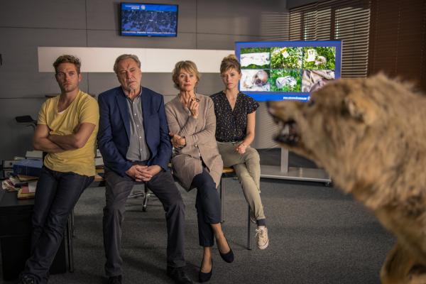 Bild 1 von 7: Dominik Morgenstern (Joscha Kiefer, l.), Arthur Bauer (Gerd Silberbauer, 2. v. l.), Kriminaldirektorin Kreiner (Ilona Grübel, 2. v. r.) und Resi Schwaiger (Mersiha Husagic, r.) betrachten den ausgestopften Wolf im Büro.