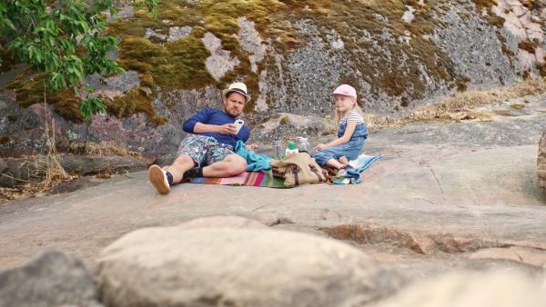 Bild 1 von 2: Vilda (Sofia Sittnikow) macht mit Papa Picknick auf einer Insel.