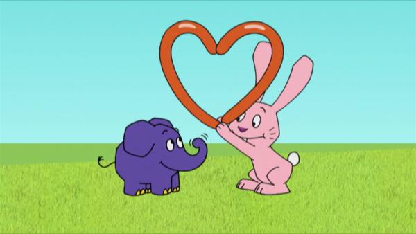 Bild 1 von 2: Hase und Elefant basteln ein Herz.