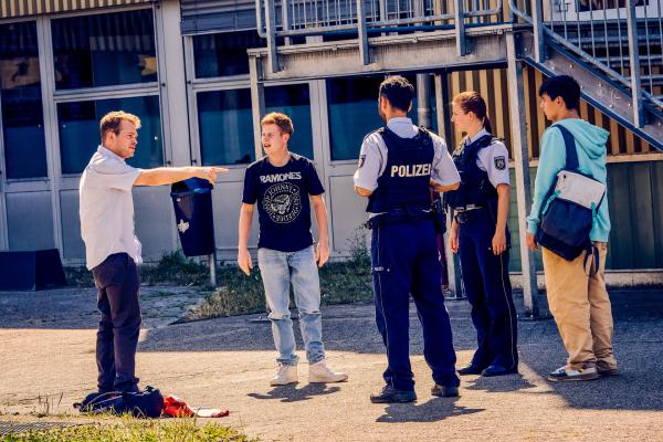 Bild 1 von 6: Ernst (Diyar Ilhan, r.) hat vor Eifersucht die Polizei auf Julian (Ben Münchow, l.) gehetzt mit der Behauptung, Julian habe Janniks (Leon Siedel, 2.v.l.) Fahrrad alleine beschädigt. Jannik, der Julian, bis eben noch für seinen Vater hielt, ist nun vollkommen verwirrt.
