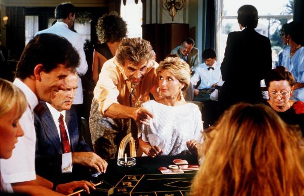 Bild 1 von 1: Im Bild: Thomas Graf Guldenburg (Wolf Roth, mi.) frönt wieder einmal seiner Spielleidenschaft und befindet sich auf der Verliererstraße. Da taucht Kitty (Susanne Uhlen) auf und schon wendet sich das Blatt.