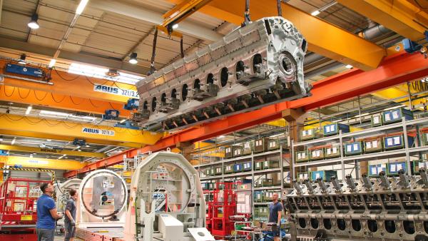 Bild 1 von 3: In mehreren Schritten wird die eiserne Grundplatte des Motors mit den Kolben, der Kurbelwelle und den Pumpen verschraubt.