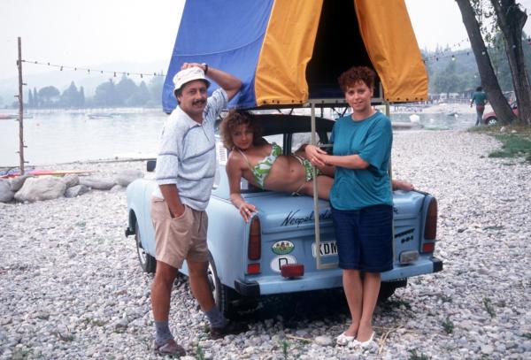 Bild 1 von 18: Familie Struutz, bestehend aus Vater Udo (Wolfgang Stumph, l.), Mutter Rita (Marie Gruber, r.) und ihrer 17-jährigen Tochter (Claudia Schmutzler, M.), lebt in Bitterfeld, einer Stadt in den neuen Bundesländern. Nach dem Mauerfall machen sich die drei mit ihrem Trabi auf nach Italien ...