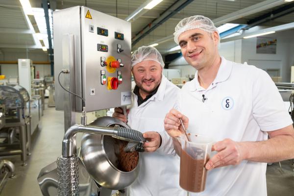 Bild 1 von 3: Sebastian Lege (l.) zeigt, wie aufwändig die m&m's-Herstellung ist und holt sich professionelle Hilfe dazu.