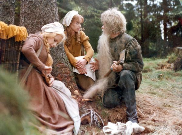 Bild 1 von 2: Schneeweißchen (Julie Juristová) und Rosenrot (Katrin Martin) versuchen, einem alten Mann (Hans-Peter Minetti) zu helfen, dessen Bart sich beim Holzfällen verfangen hat.