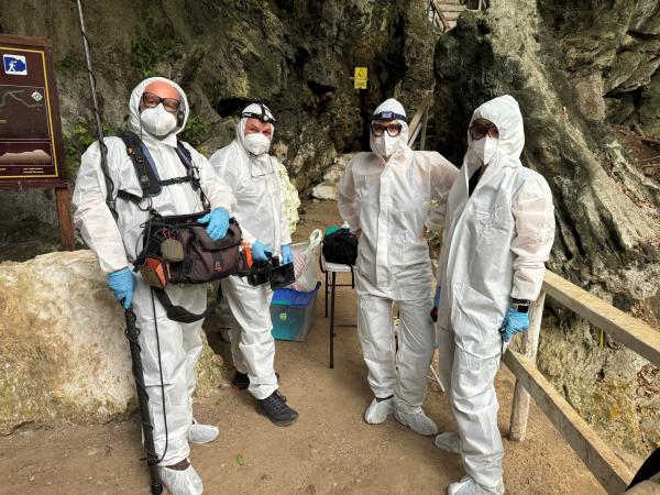 Bild 1 von 11: Forschung in einer Höhle im Dschungel. Da Fledermäuse Krankheiten übertragen können, muss das gesamte Team Schutzkleidung tragen. Von links: Thorsten Czart (Ton), Oliver Roetz (Kamera), Hannah Emde (Host), Iris Zink (Redakteurin)