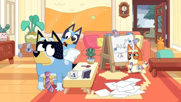 Bild 1 von 3: Bingo und Bluey spielen mit Papa Arbeit. Er engagiert sie als Mitarbeiter für seine Fabrik. Doch als Bluey das Kommando übernimmt, ist Papa unzufrieden, weil sie sehr streng ist und ihnen sogar das Tanzen verbietet.
