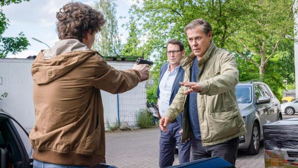 Bild 1 von 19: Im Bild: Bei einer Fahrzeugkontrolle zieht Arthur Grün (Nico Ramon Kleemann, l.) plötzlich eine Schusswaffe und bedroht damit Lars (Ingo Naujoks, 2.v.r.) und Finn (Sven Martinek, r.).