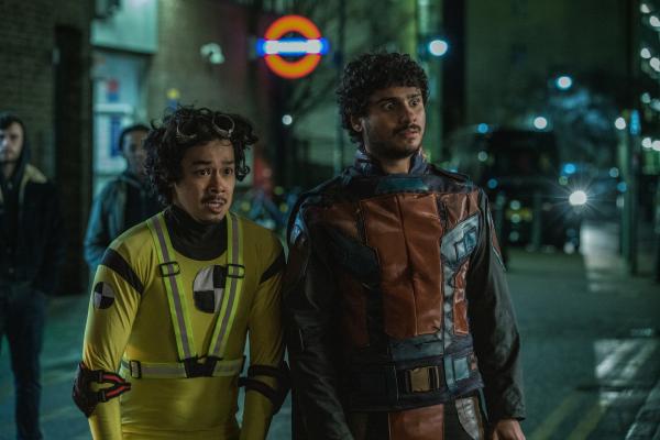 Bild 1 von 3: Gregor (Chris Lew Kum Hoi, l.) und Kash (Bilal Hasna, r.) stehen machtlos am Straßenrand, während andere Mitglieder der Bürgerwehr in einen gefährlichen Konflikt hineingezogen werden.