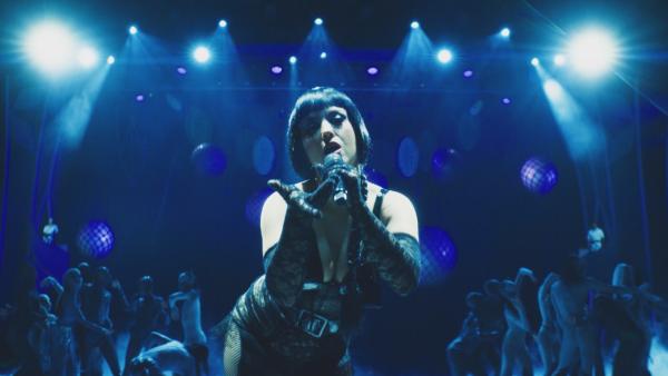 Bild 1 von 3: Eine Sängerin fesselt das Publikum im blauen Licht der Palastbühne.