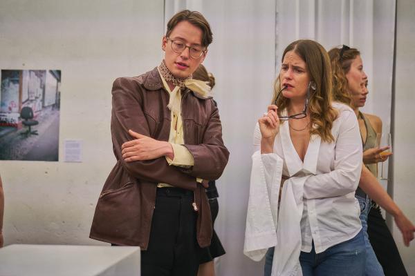 Bild 1 von 4: Frau Gröner (Isabell Polak, M.) philosophiert mit einem Ausstellungsbesucher (Komparse, l.) über Kunst.