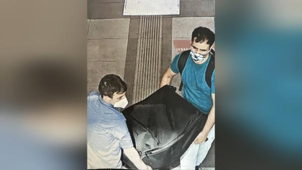 Bild 1 von 6: Die Tatverdächtigen tragen einen offensichtlich schweren Koffer aus einem Taxi in das Bahnhofsgebäude \