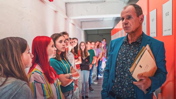Bild 1 von 5: Herr Zech (Olaf Burmeister, re.) führt seine Exkursionsgruppe durch den Aktenkeller des Stasi-Unterlagen-Archivs.