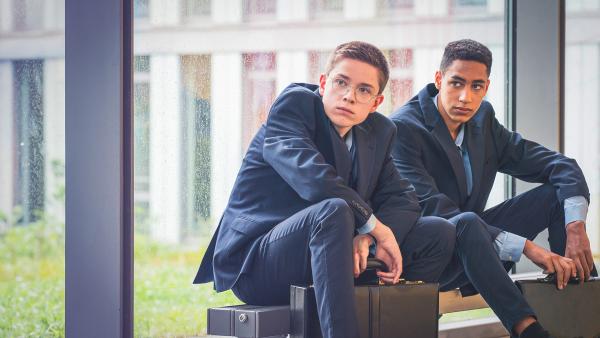 Bild 1 von 5: Joshua (Georg Trappe, links) will Malik (Jonathan Vöhringer, rechts) dabei helfen, Direktor Chung davon zu überzeugen, nicht am Survival Camp teilnehmen zu müssen.