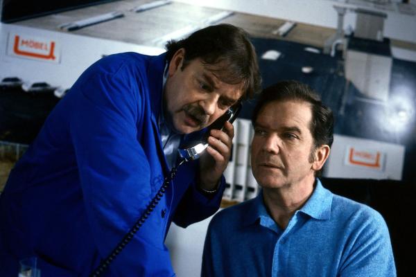 Bild 1 von 3: Ein Telefonat mit Eberhard auf Mallorca wird von Werkmeister Heinz (Andreas Mannkopff, l.) und Tenstaag (Gerhard Friedrich, r.) völlig falsch gedeutet.