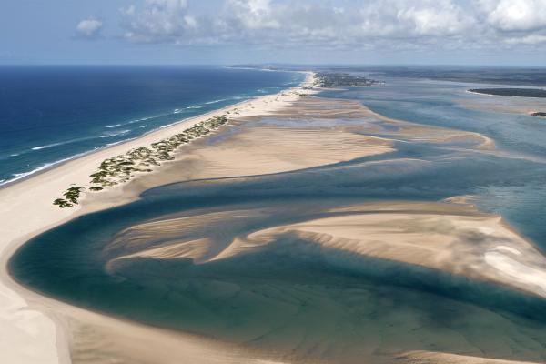 Bild 1 von 3: Die Dünen aus feinem Sand türmen sich haushoch. Unter dem Wasser bietet ein Riffaus mehr als hundert Korallenarten Lebensraum für unzählige Tierarten.