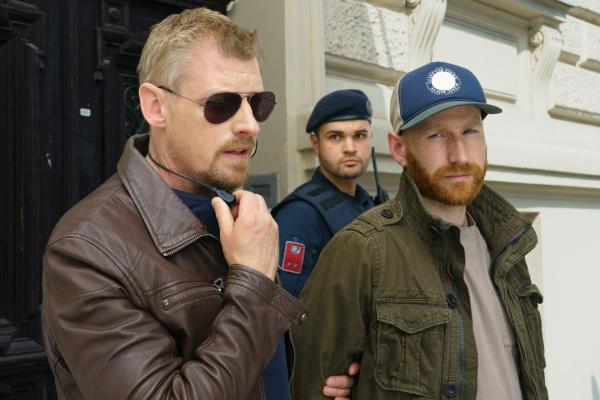 Bild 1 von 5: Major Max Herzog (Martin Gruber, l.) hat Richard Odner (Florian Sebastian Fitz, r.) in Gewahrsam genommen, damit er seiner Ex-Freundin nicht mehr auflauern kann. (Komparse im Bild).