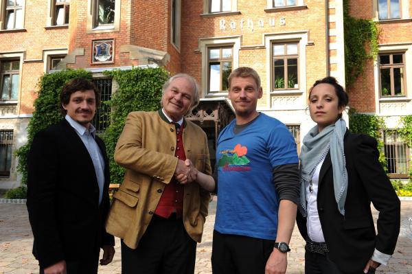 Bild 1 von 6: Hotelier Peter Herbrechter (Michael König, 2.v.l.) schüttelt Andreas Marthaler (Martin Gruber, 2.v.r.) vor der Presse die Hand. Die Teilhaber des Hotels, Tobias Herbrechter (Markus Brandl, l.) und Sarah Kraus (Stephanie Stumph, r.), begleiten sie zu diesem Termin.