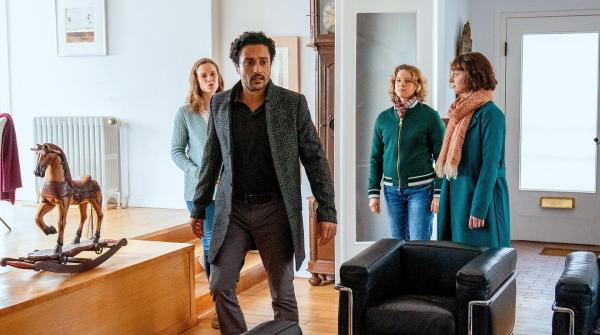 Bild 1 von 4: Im Bild: Ida Müller-Dogan (Amelie Plaas-Link, r.) und Tomke Jennsen (Anjorka Strechel, 2.v.r.) begleiten Dr. Jamal Bassad (Omar El-Saeidi, 2.v.l.) nach Hause, um seinen Rechner mitzunehmen und treffen dort auf seine überraschte Frau Line (Picco von Groote, l.).