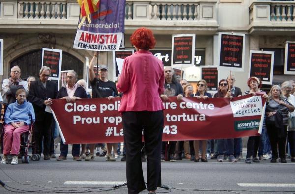 Bild 1 von 2: Pillar steht einer Gruppe von Demonstranten gegenüber.